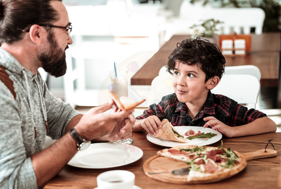 father and son eating in pizza restaurant
