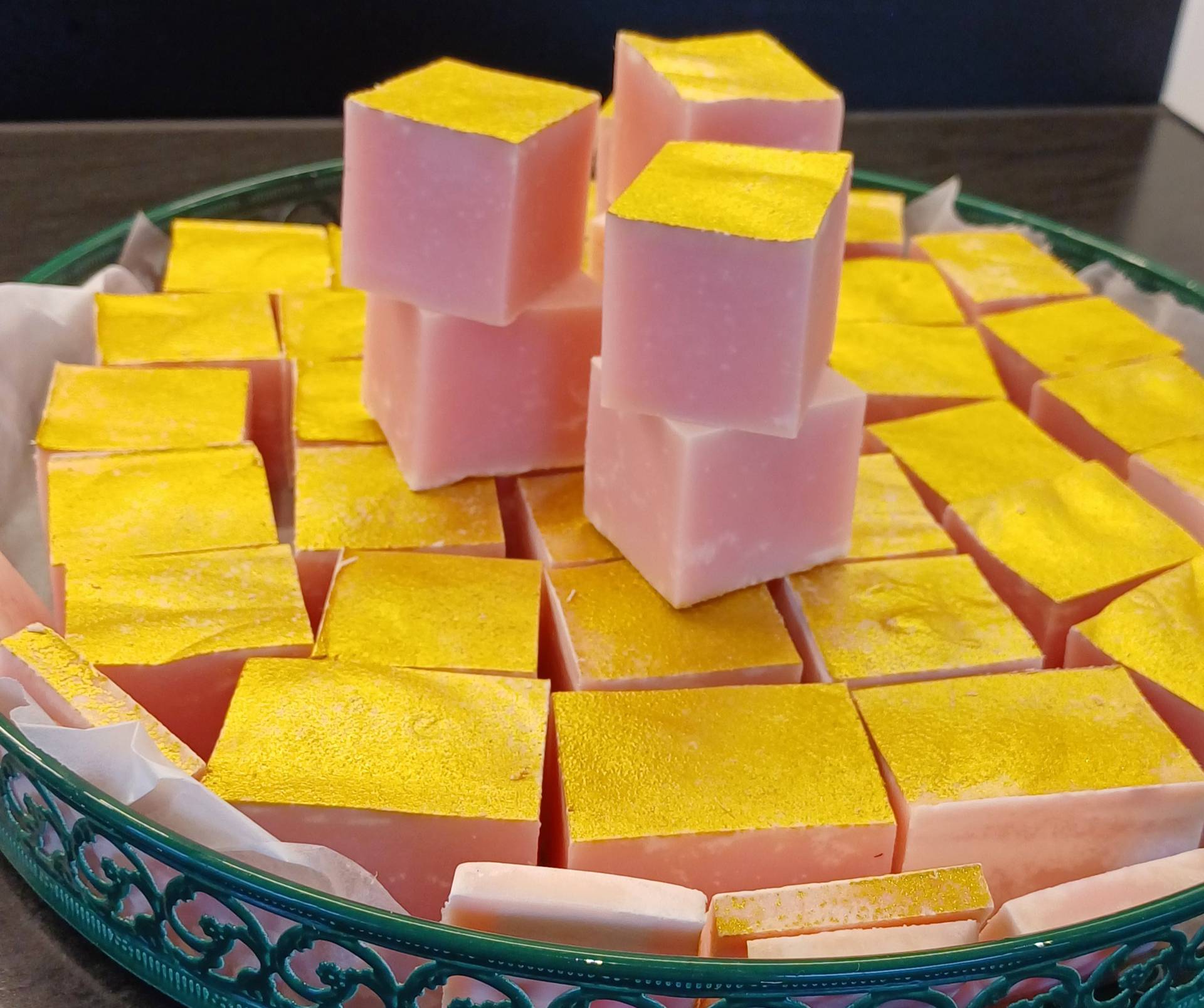 Natural soap cut in cubes full of natural ingredients and covered in a golden powder to nourish skin and hair.  