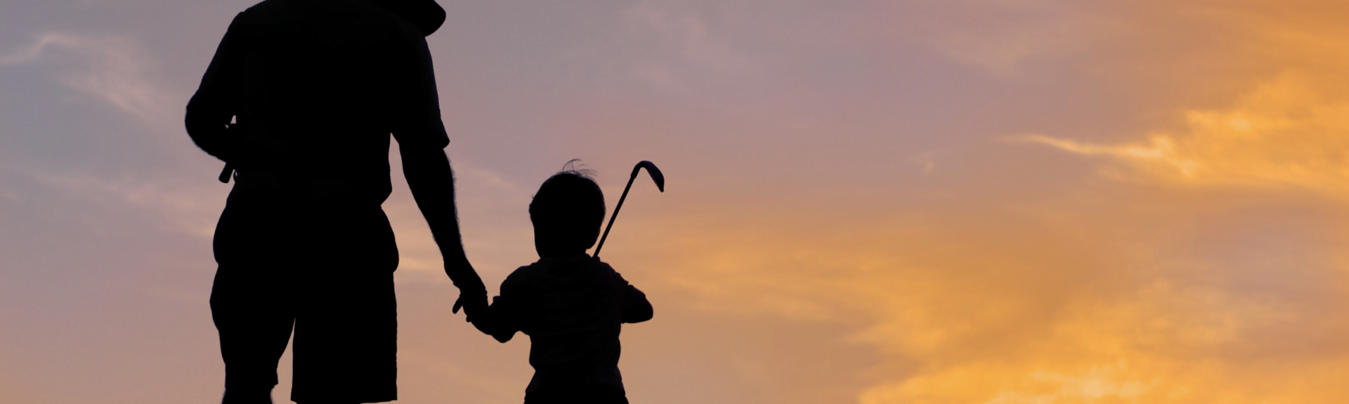 Young boy golfing with his father during sunset at Urbangolf, Winterthur 