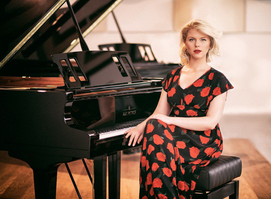 A photo of the piano teacher Ellen Fischerove by a grand piano.