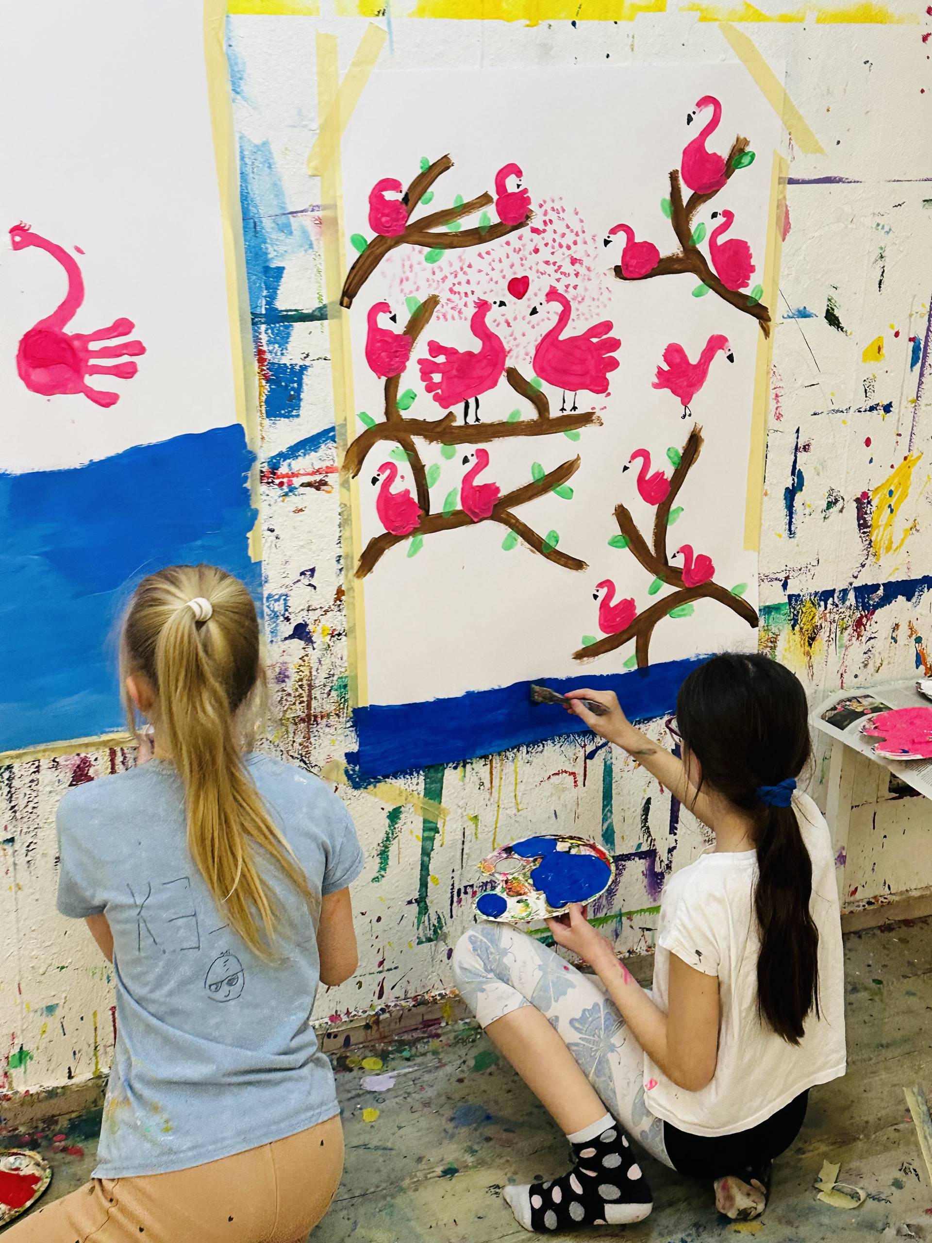 tween girls painting art on wall