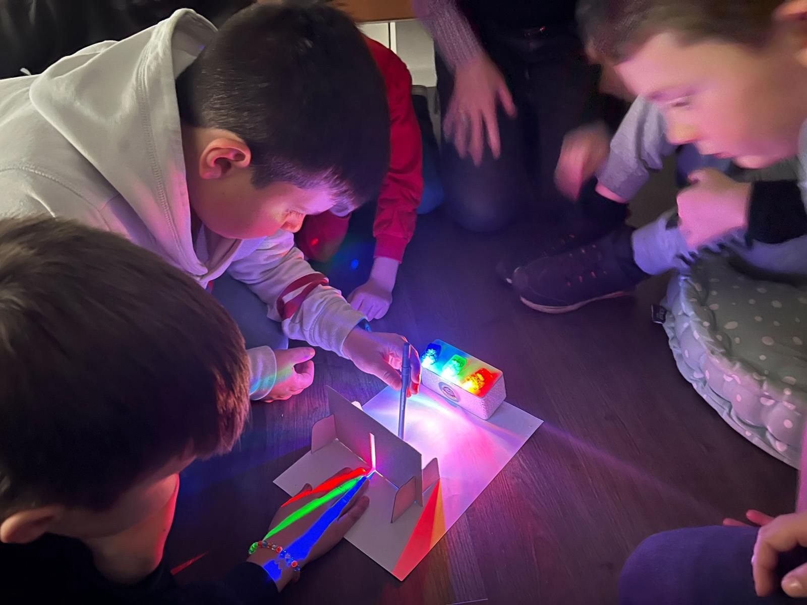 Children exploring light and colour mixing in a hands-on science experiment at a Masters of Tomorrow workshop