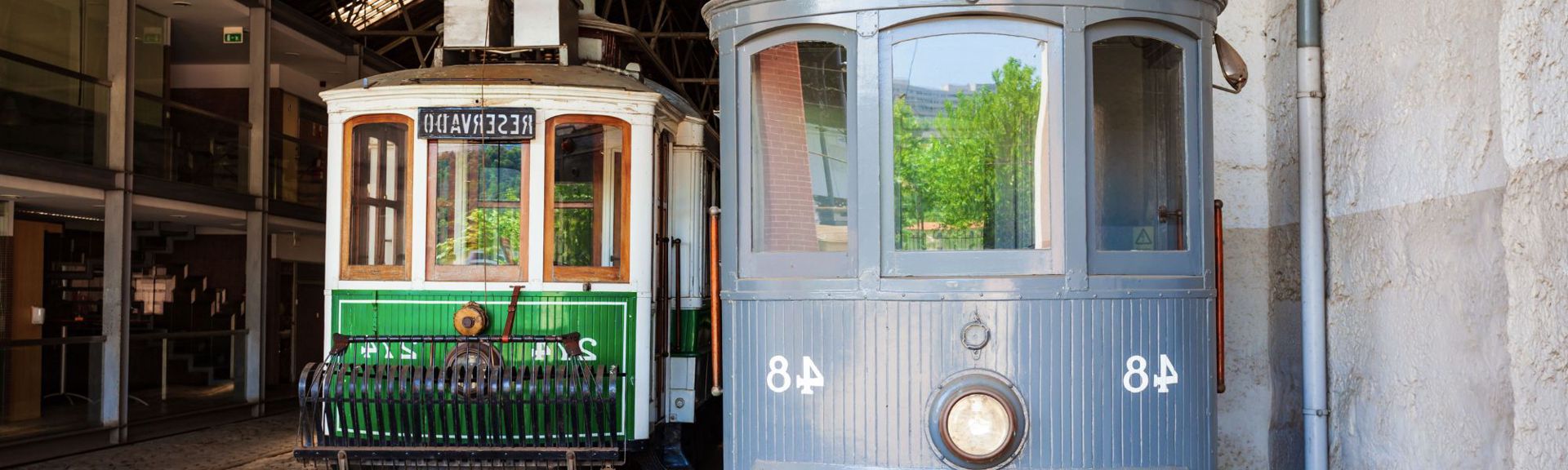Historic trams on display at the Tram Museum Zurich, with children and families exploring vintage vehicles, interactive exhibits, and transportation history in a nostalgic setting.