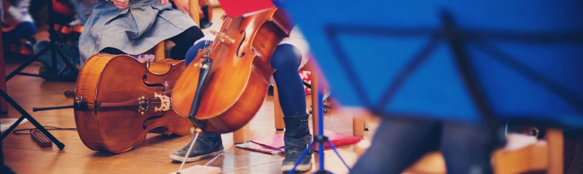 Young children seated on floor mats, attentively watching Zurich Chamber Orchestra musicians perform during a family concert at ZKO Haus.