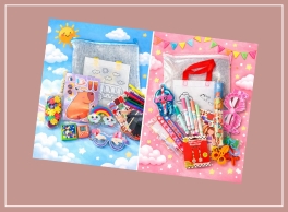 Two vibrant children's craft kits displayed on a patterned background. The left kit features a blue sky with white clouds and a yellow sun, containing colorful craft items like markers, stickers, rainbow-shaped clips, and coloring sheets. The right kit has a pink sky with white clouds and bunting, including items like colored pencils, spools of ribbon, scissors, and decorative bows. Both kits are designed to inspire creativity and are packed with playful, child-friendly materials.