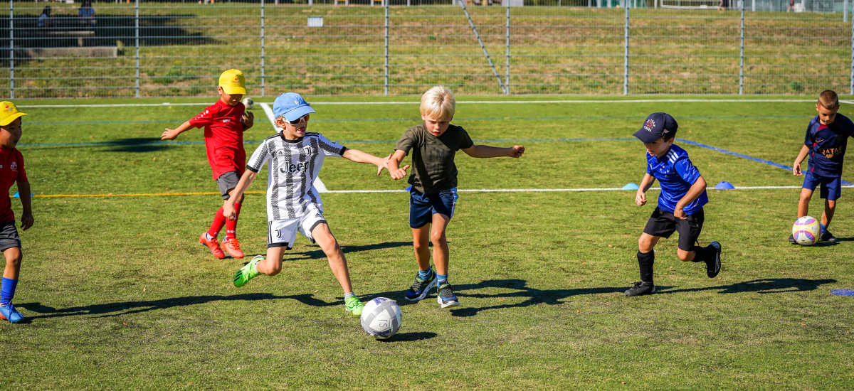 Children playing football on a summer's day at Intersoccer after-school classes in Zug, Switzerland. 