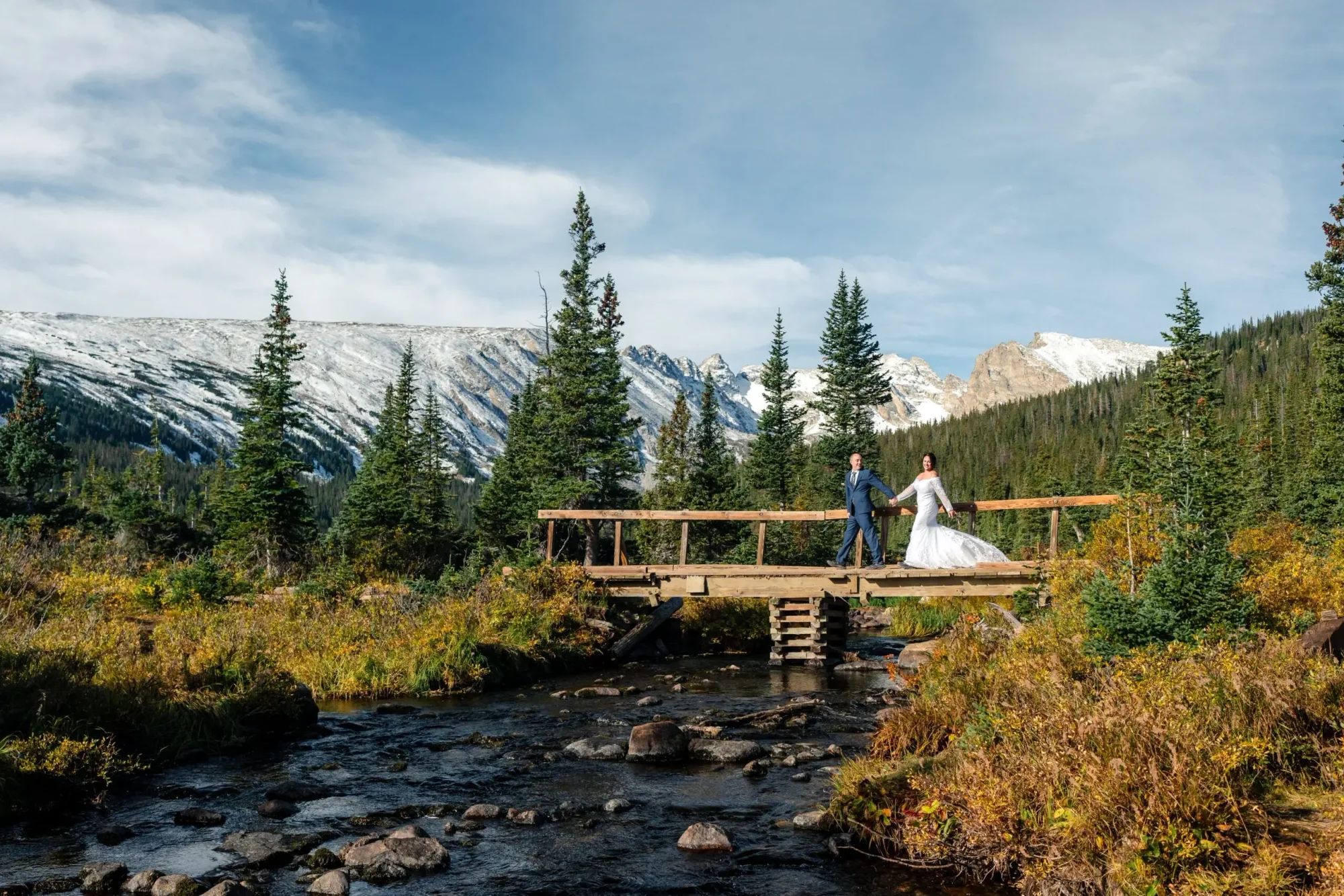 Colorado Outdoor Weddings ζευγάρι σε ξύλινη γέφυρα πάνω από ρέμα το φθινόπωρο