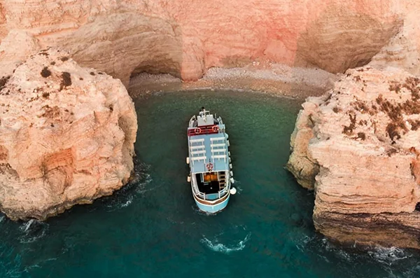 Mavros G Boat Tours boat cruising between rocks at Koufonisia